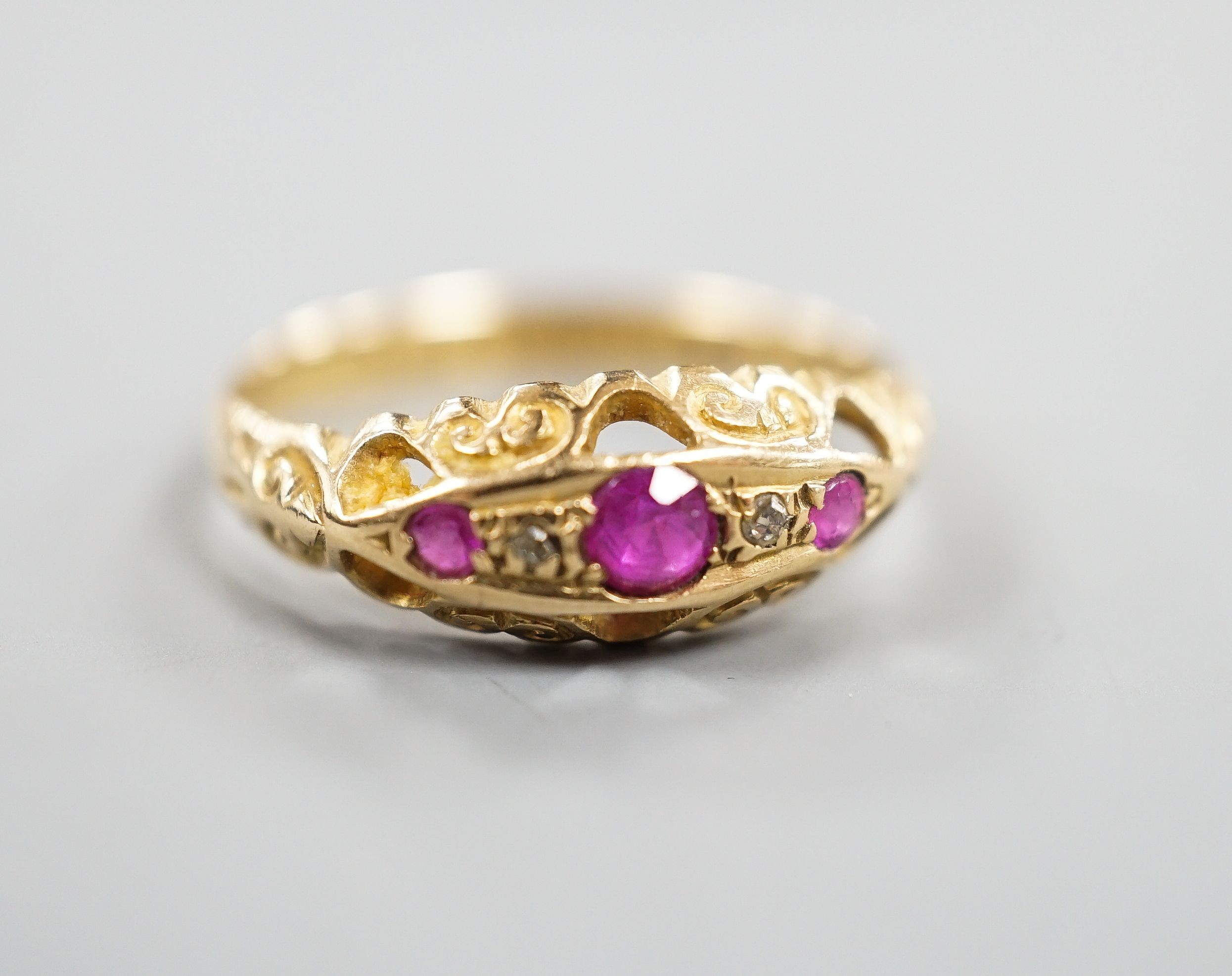 A George V 18ct gold three stone ruby and two stone diamond chip set ring, size Q, gross weight 3 grams.